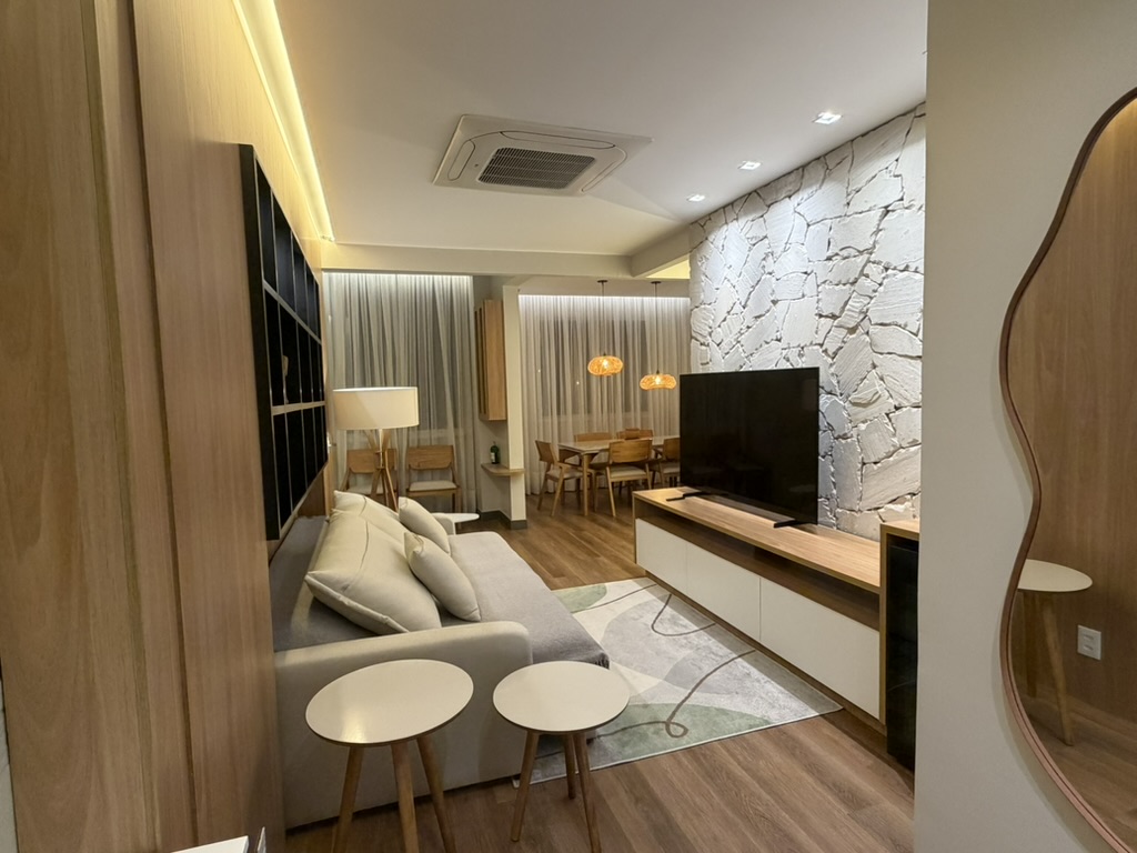 Warmly lit living room with sofa, stone wall and dining area