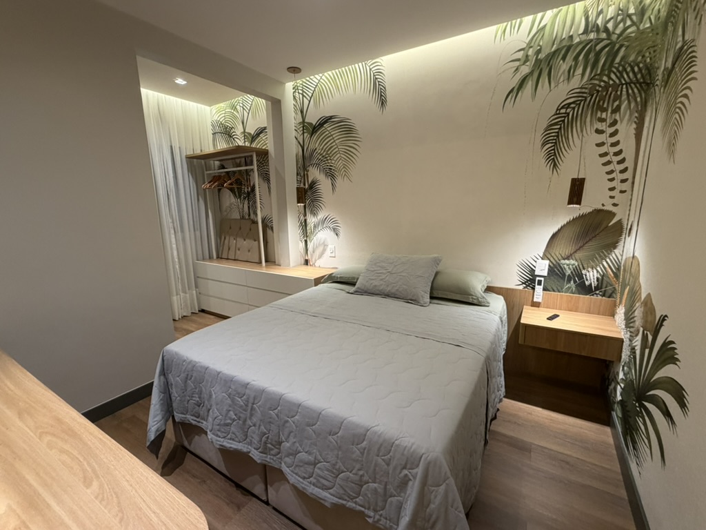 Bedroom with bed, botanical wall covering and warm integrated lighting